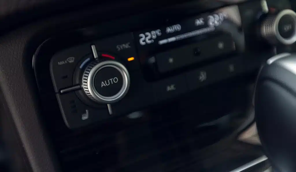 Foto do painel de um carro moderno com indicação da temperatura do ar-condicionado.